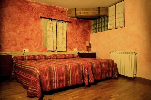 a bedroom with a large bed with a red blanket at Casa Rural "La Bardena Blanca I " in Arguedas