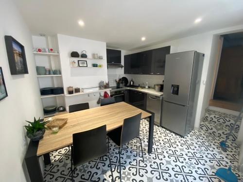 a kitchen with a wooden table and a refrigerator at MAISONNETTE de charme avec cour privative Haute-Ville GRANVILLE in Granville