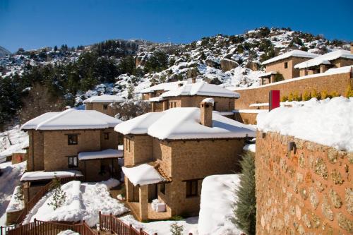 a village covered in snow with a mountain in the background at Pliadon Gi Mountain Resort & Spa in Kato Trikala Korinthias