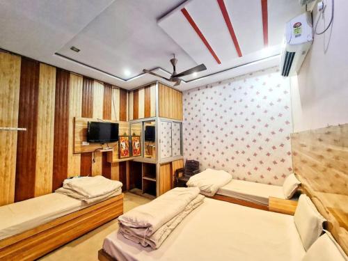 Habitación con 2 camas y TV. en Goroomgo Sangam Palace Guest house Mathura - Prime Location en Mathura