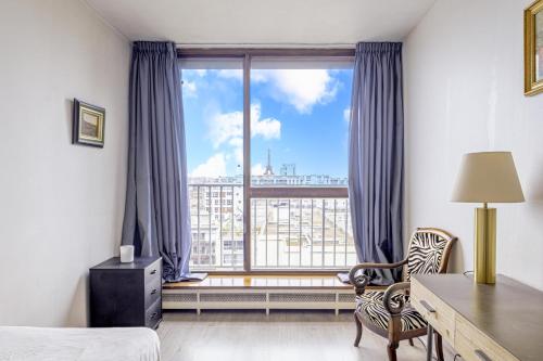 - une chambre avec un bureau et une grande fenêtre dans l'établissement NEW - 3 bedroom flat with Eiffel Tower view, à Paris