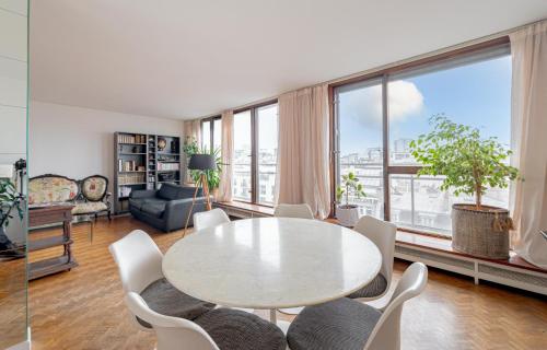 un salon avec une table et des chaises dans l'établissement NEW - 3 bedroom flat with Eiffel Tower view, à Paris