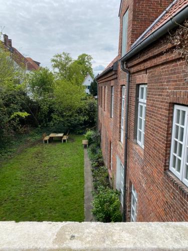 a view of a yard next to a brick building at Wohlfühlen in historischem Haus in Brake