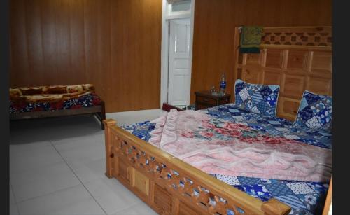 a bedroom with a large wooden bed and a couch at New White Palace Hotel in Nārān