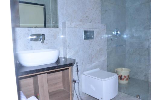 a bathroom with a sink and a toilet and a shower at Hotel Nand Residency in Ghāzīpur