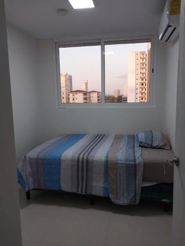 1 dormitorio con 1 cama frente a una ventana en Roomstay Pty en Panamá