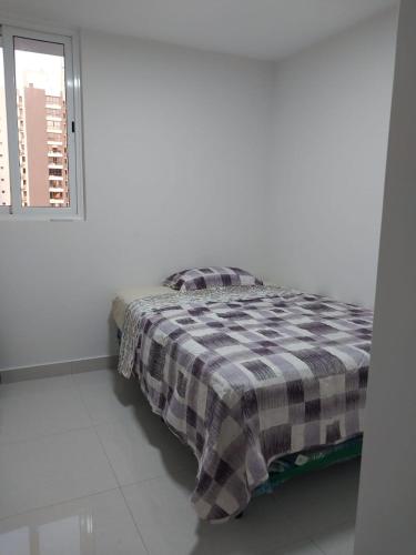 Cama en habitación blanca con ventana en Roomstay Pty en Panamá