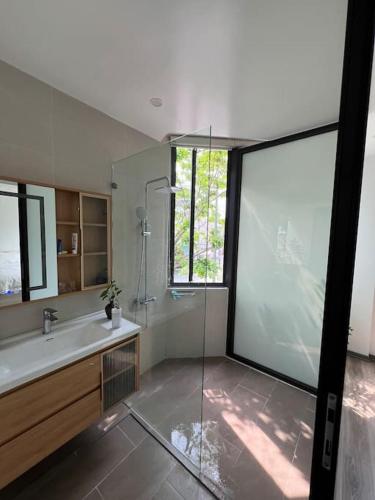 a bathroom with a shower and a sink and a mirror at Rosemary's in Ha Long