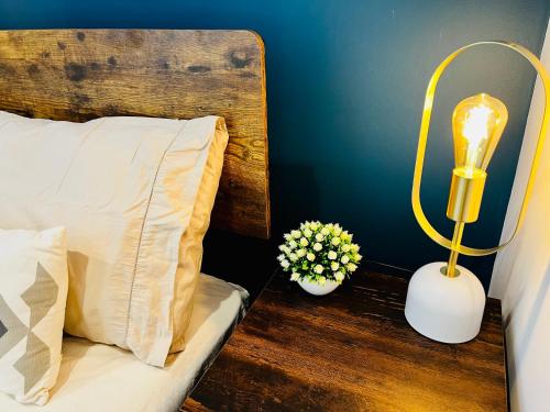 a bedroom with a bed with a lamp and flowers at Refugio do Gato in Palmela