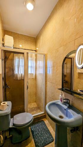ein Bad mit einer Dusche, einem Waschbecken und einem WC in der Unterkunft The Zen Haven in Uyo