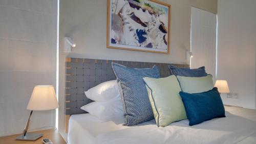 a bed with blue and white pillows on it at Appart de Standing, Plage à 200m à Pieds in Grand Baie