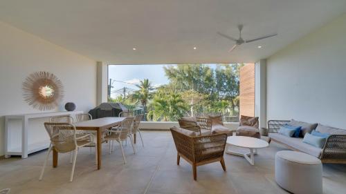 a living room with a table and chairs and a couch at Appart de Standing, Plage à 200m à Pieds in Grand Baie