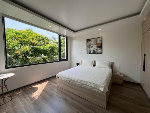 a bedroom with a bed and a large window at Rosemary's in Ha Long