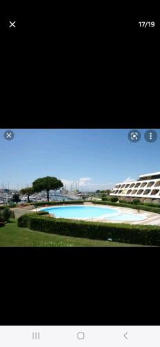 une capture d'écran d'une photo d'une piscine dans l'établissement Studio 4 personnes vue MER et PORT, au Grau-du-Roi