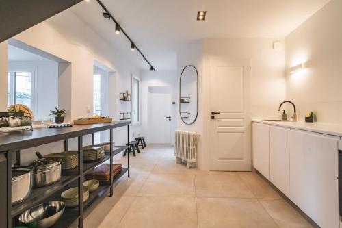 a large kitchen with white cabinets and a counter top at Charmante maison proche centre-ville Reims in Reims