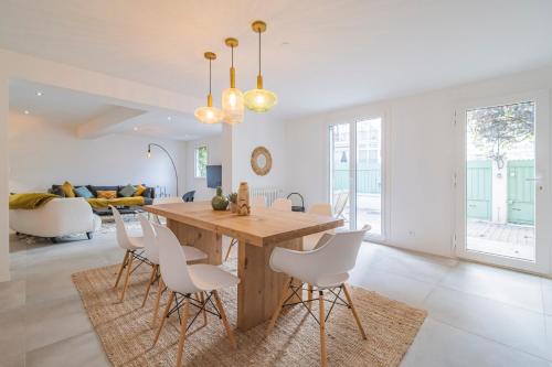 une cuisine et une salle à manger avec une table et des chaises en bois dans l'établissement Charmante maison proche centre-ville Reims, à Reims