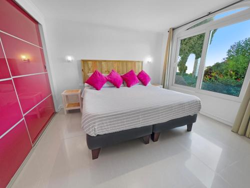 a bedroom with a bed with pink pillows and a window at Puerto Velero Primera Línea Primer Piso al lado de la Playa! 8pax in Puerto Velero