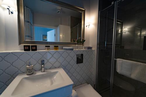 a bathroom with a sink and a mirror at Edel Exclusive Apartments Villa Marea 58 Especially for You in Międzyzdroje