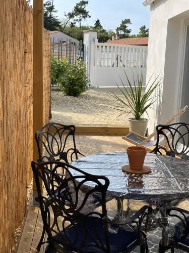 a patio with a table and chairs and a fence at Chez Catherine in Les Sables Vignier
