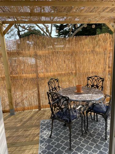 a patio with a table and chairs and a fence at Chez Catherine in Les Sables Vignier