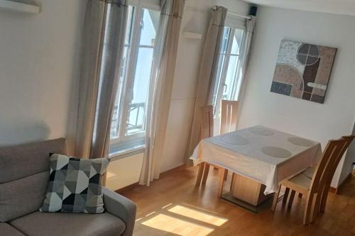 un salon avec une table et un canapé dans l'établissement 2 chambres au pied du métro, à Maisons-Alfort