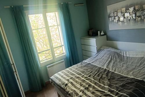 une chambre avec un lit et une fenêtre dans l'établissement 2 chambres au pied du métro, à Maisons-Alfort