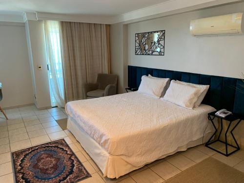 a bedroom with a large bed and a chair at FLAT HOTEL BEIRA MAR AV BOA VIAGEM Recife in Recife