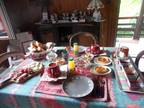 une table avec un tissu de table et de la nourriture dans l'établissement Les Fougères, à Sévrier