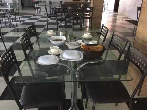 a glass table with chairs and a bowl on it at New Hilton Hotel in Naran