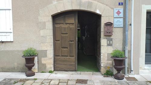 - une entrée pour un bâtiment avec une porte en bois dans l'établissement Appart 2 pièces et jardin hyper centre ville, à Angers