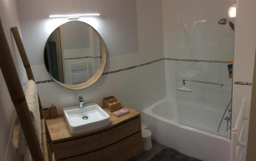 une salle de bain avec un lavabo, un miroir et une baignoire dans l'établissement Appartement calme et cosy à Mandelieu, à Mandelieu-la-Napoule