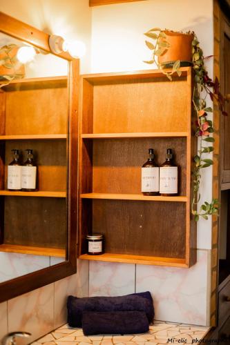 a shelf with three bottles of soap on it at MANGA BLUE'S GUEST HOUSE in Fianarantsoa
