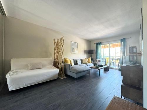 - un salon avec un lit blanc et un canapé dans l'établissement Appartement calme et cosy à Mandelieu, à Mandelieu-la-Napoule