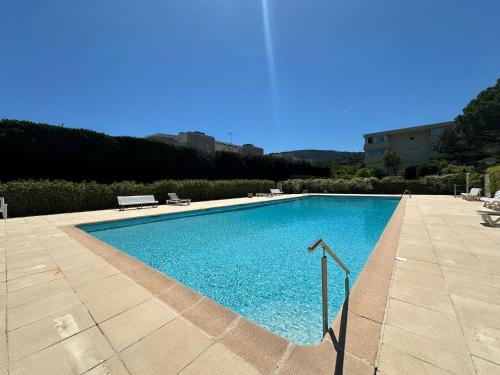 une grande piscine bleue avec un banc à côté dans l'établissement Appartement calme et cosy à Mandelieu, à Mandelieu-la-Napoule