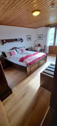 a bedroom with a large bed with a wooden ceiling at Hotel Fassbind Beausite in Beatenberg