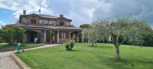 a woman standing in front of a house at Appartamento in villa Gra&Mary in San Giovanni in Marignano