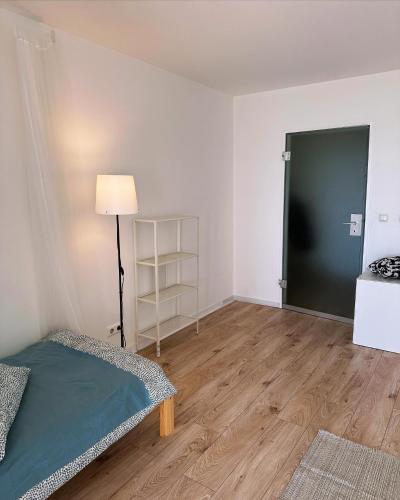 Habitación con cama, lámpara y puerta en Cozy sunny apartment for one, en Múnich