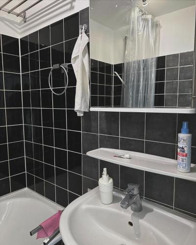 y baño con lavabo, bañera y espejo. en Cozy sunny apartment for one, en Múnich