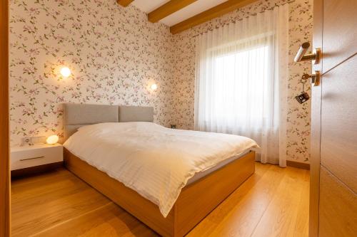 niewielka sypialnia z łóżkiem i oknem w obiekcie Black Swan w mieście Brocēni