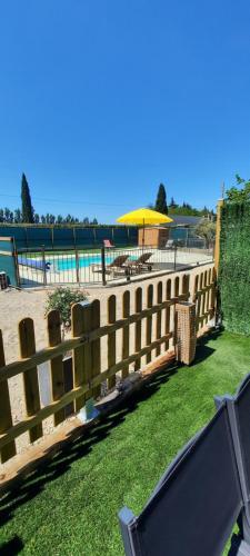 une clôture en bois à côté d'une masse d'eau dans l'établissement Appart'Estel 2 pers en campagne avec terrasse et accès piscine, à Tarascon