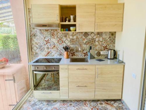 a small kitchen with wooden cabinets and a sink at Casa Limone in Quartu sant Elena, Capitana, with sea view! in Capitana