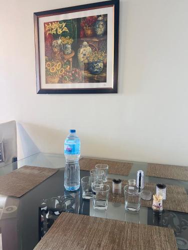 a table with glasses and a bottle of water on it at Blue sky Apartment in Nathia Gali