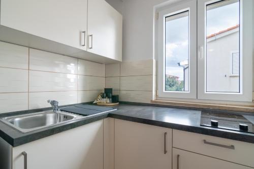 a kitchen with a sink and a window at Apartments Josipa in Mandre