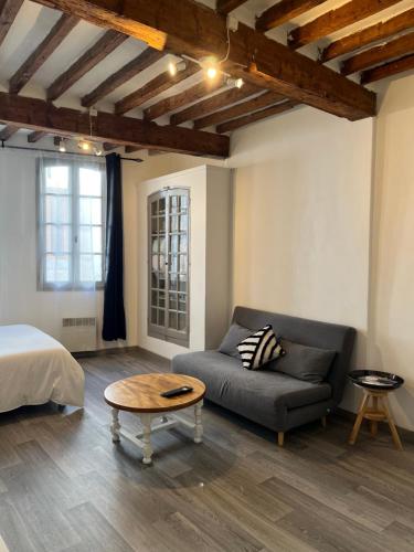 Habitación con cama, sofá y mesa. en Studio Charmant au Cœur de Carpentras, en Carpentras