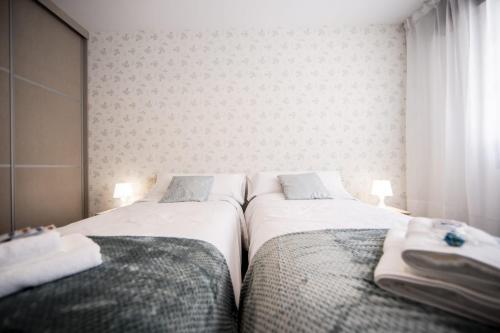 two beds sitting next to each other in a bedroom at Dulces Estancias in Lalín