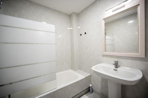 a white bathroom with a sink and a mirror at Dulces Estancias in Lalín