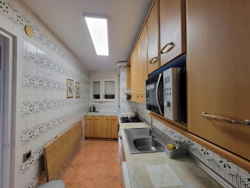 a kitchen with a sink and a microwave at SALOU FAMILY APARTMENT in Salou