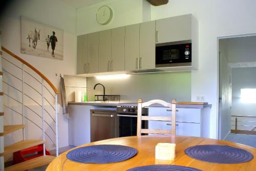 a kitchen with a wooden table with plates on it at Manoir de la Haute Couplais in Romille