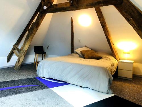 a bedroom with a bed in the attic at Manoir de la Haute Couplais in Romille
