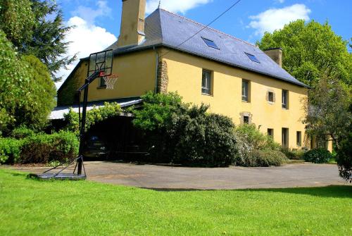 a yellow house with a basketball hoop in front of it at Manoir de la Haute Couplais in Romille